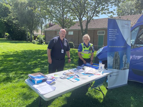 Alan with PCSO stood at an information stand. Smiling on a sunny day