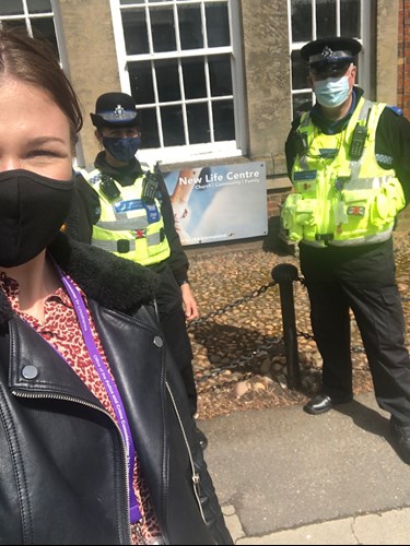 Roising wearing a covid face mask, stood with 2 uniformed police officers
