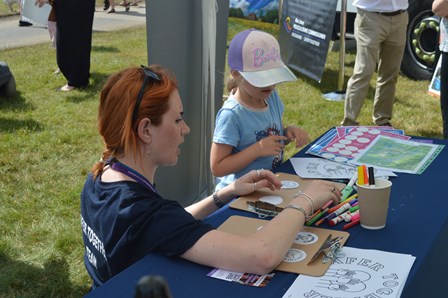 Maisie colouring in badges with a young person.